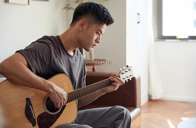 Молодой человек играет на гитаре дома изображение_Фото номер 501687435_JPG  Формат изображения_