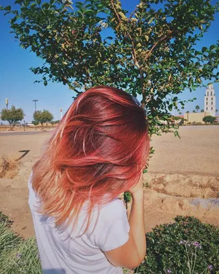 Девушка с рыжими волосами на качелях у водопада