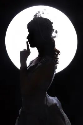 Фото Девушка на фоне полной луны стоит на перекладине между двумя деревьями