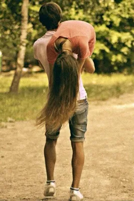 Парень держит девушку на руках и смеется против студии | Премиум Фото