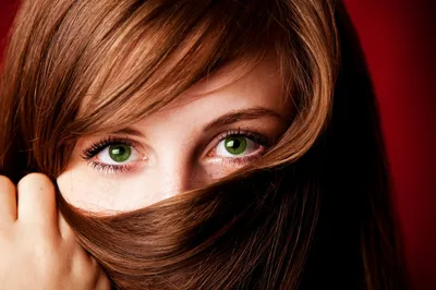 Фотография с большими зелеными глазами и цветком в волосах
