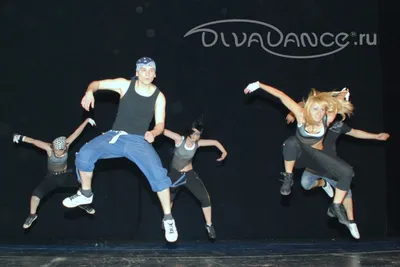 Полное тело стройной молодой танцовщицы хип-хопа в спортивной одежде,  исполняющей танцевальное движение в белой студии | Премиум Фото