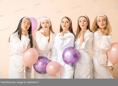 Красивые молодые женщины в халатах и с воздушными шариками дуют поцелуй на  светлом фоне :: Стоковая фотография :: Pixel-Shot Studio