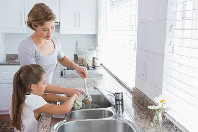 Мама домохозяйки в розовых перчатках моет посуду со своим сыном вручную в  раковину с тензидом. Девушка в белом и ребенок с a Стоковое Изображение -  изображение насчитывающей мама, дом: 187478599