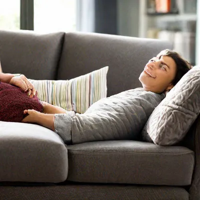 Молодой человек слушает музыку во время отдыха на диване у себя дома ::  Стоковая фотография :: Pixel-Shot Studio