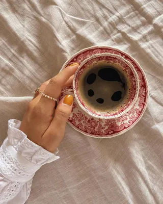 Фото Рука девушки у чашки с кофе на блюдце