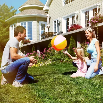 Фото Счастливая семья на лужайке возле своего дома